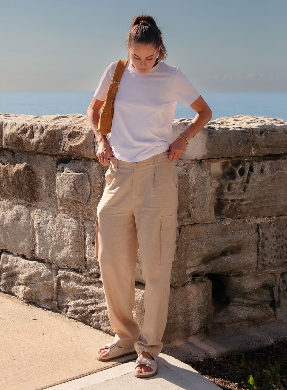 Athena Linen Cargo Pant in beige is 100% Linen, elastic waistband at back, belt loops, slightly tapered towards the hem, 2 Pockets at back, 2 Pockets on side leg