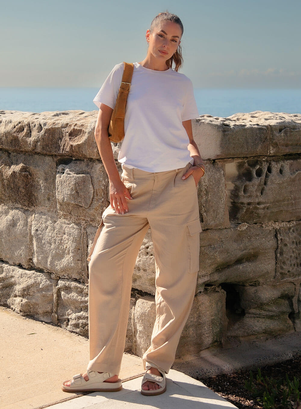 Athena Linen Cargo Pant in beige is 100% Linen, elastic waistband at back, belt loops, slightly tapered towards the hem, 2 Pockets at back, 2 Pockets on side leg