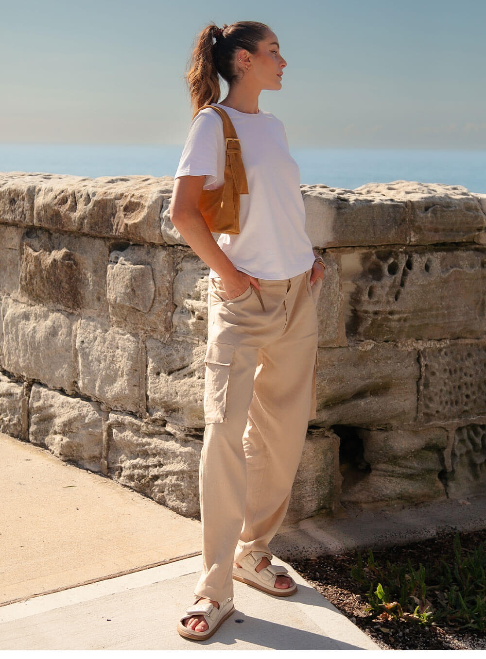Athena Linen Cargo Pant in beige is 100% Linen, elastic waistband at back, belt loops, slightly tapered towards the hem, 2 Pockets at back, 2 Pockets on side leg