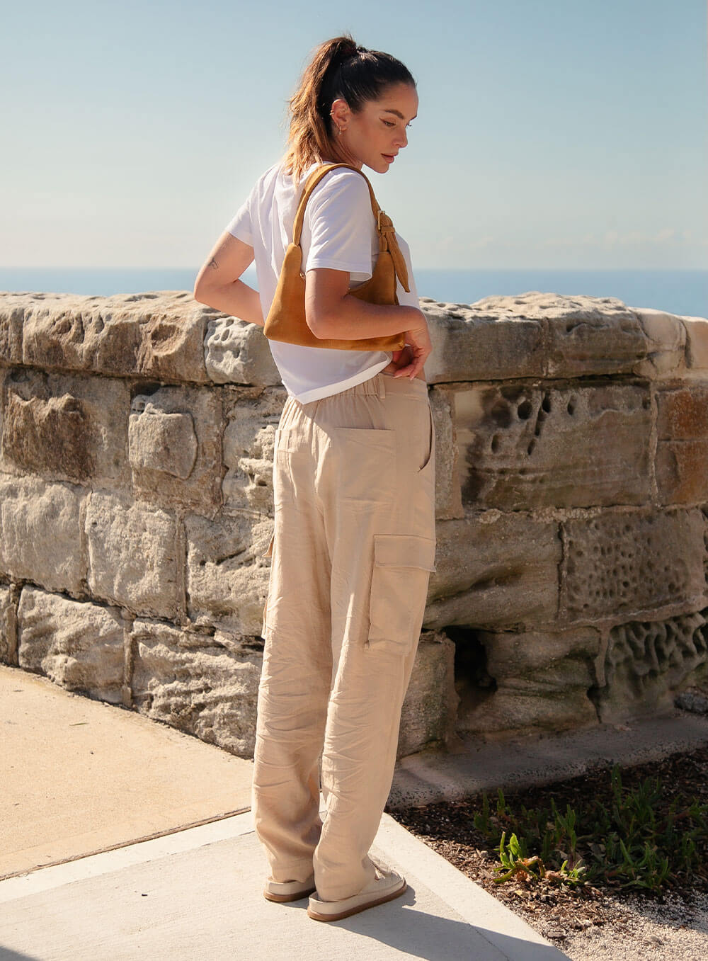 Athena Linen Cargo Pant in beige is 100% Linen, elastic waistband at back, belt loops, slightly tapered towards the hem, 2 Pockets at back, 2 Pockets on side leg