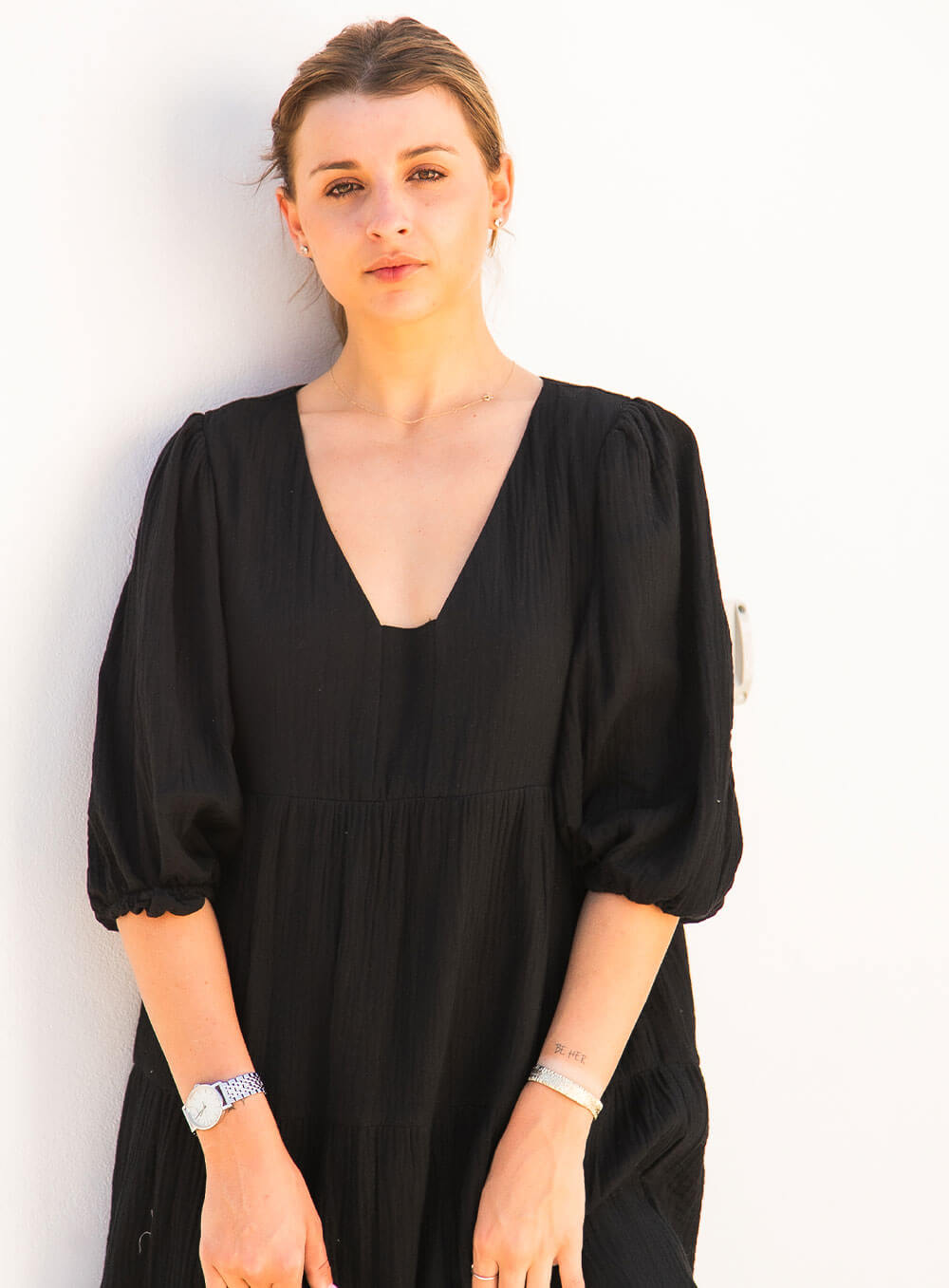 The Olive Dress in black is mid length, lined, features elasticated sleeve, tiered style front bodice detailing.