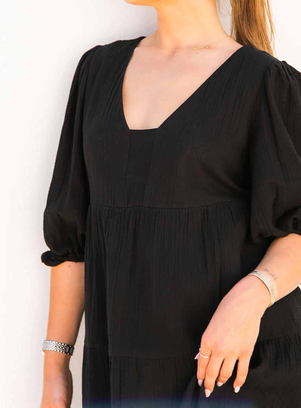 The Olive Dress in black is mid length, lined, features elasticated sleeve, tiered style front bodice detailing.