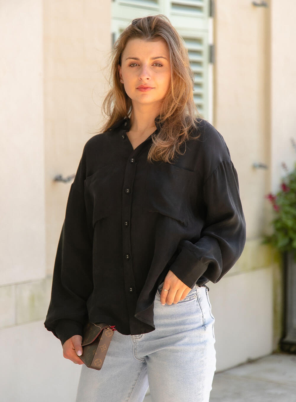 The Sienna Cupro shirt in black is a long sleeve soft velvet feeling long sleeve shirt with 2 chest pockets, scoop hem and self fabric buttons down the front.