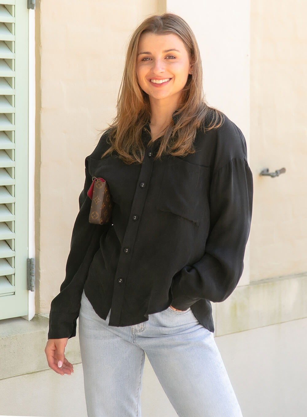 The Sienna Cupro shirt in black is a long sleeve soft velvet feeling long sleeve shirt with 2 chest pockets, scoop hem and self fabric buttons down the front.
