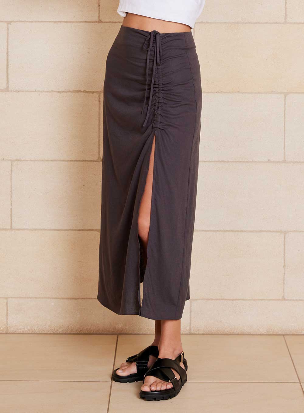 The Lily Skirt in charcoal features a ruched split detailing that adds both shape and texture, functional ruching with tie leg splits and invisible zip back seam.