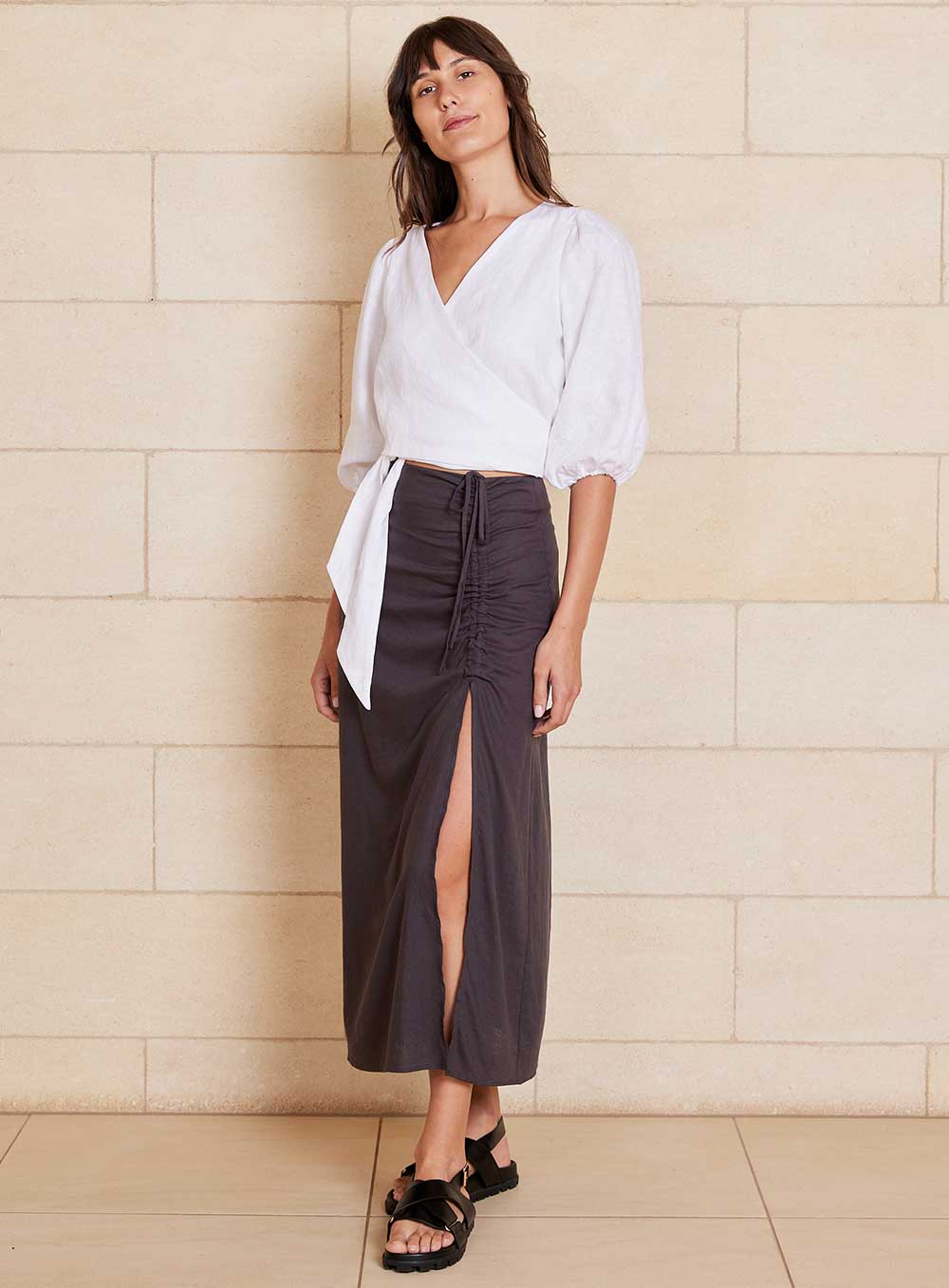 The Lily Skirt in charcoal features a ruched split detailing that adds both shape and texture, functional ruching with tie leg splits and invisible zip back seam.