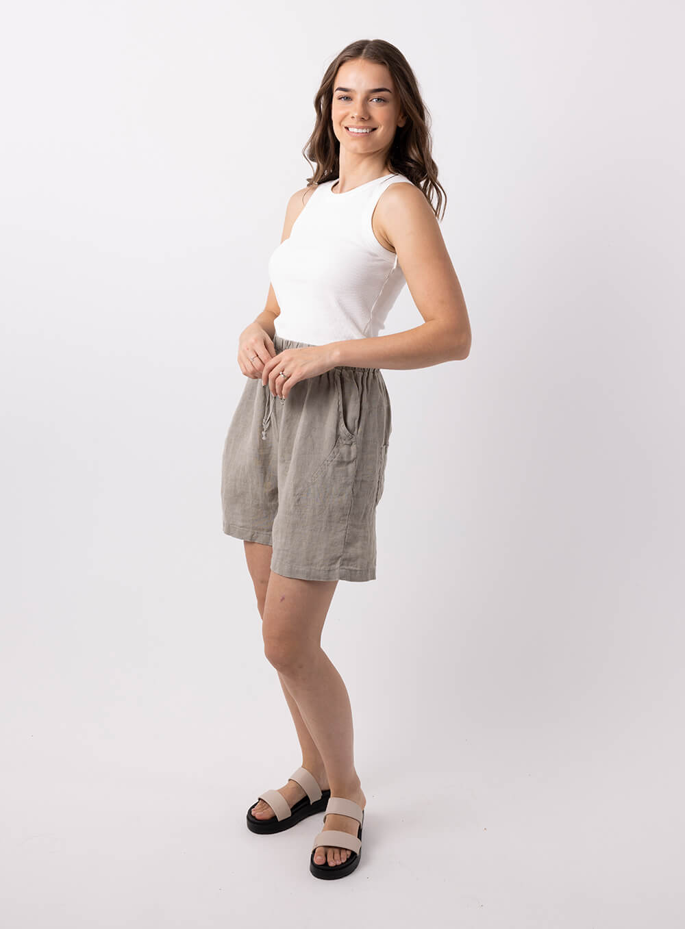 Adeline linen short in sage has 20mm elestic wiast band with tie. It has 2 side pockets, is mid thigh length with 100% breathabe linen fabric.. 
