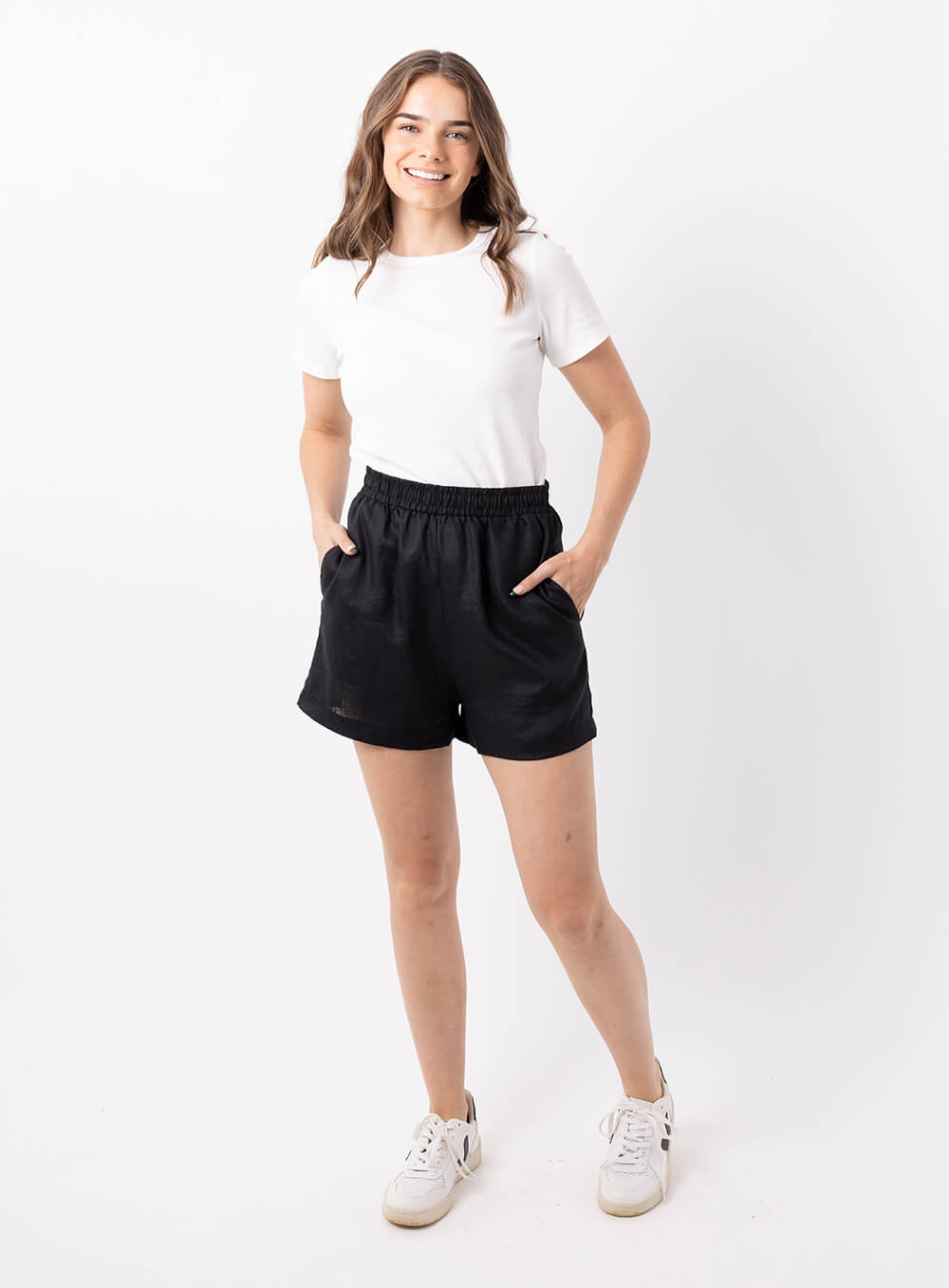 The Ali Linen Short in black is 100% breathable lien, mid thigh in length with 2 side pockets, no back pockets, elastic waistband and designed to be worn high wiasted and loose fitting