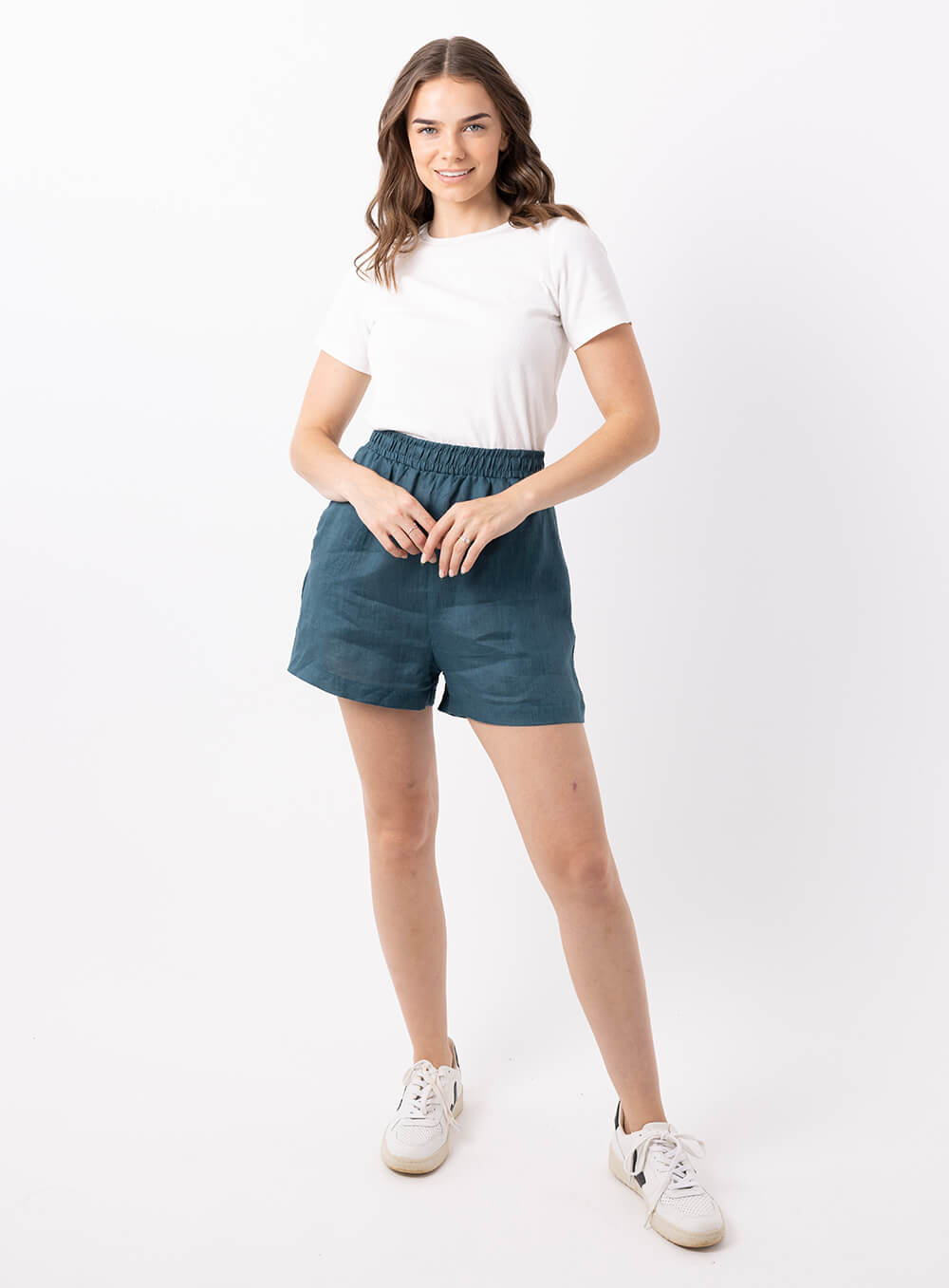 The Ali Linen Short in teal is 100% breathable lien, mid thigh in length with 2 side pockets, no back pockets, elastic waistband and designed to be worn high wiasted and loose fitting