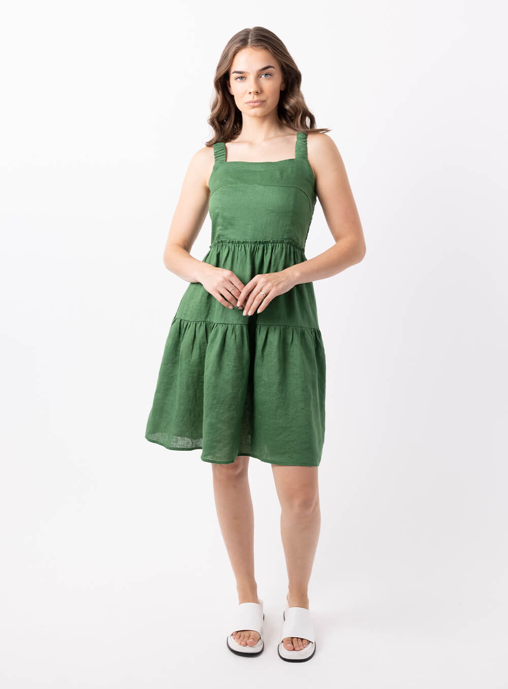 The Aquila linen dress in Green is 100% breathable linen midi in length with a tiered skirt, thin rouched straps and sqquare neckline