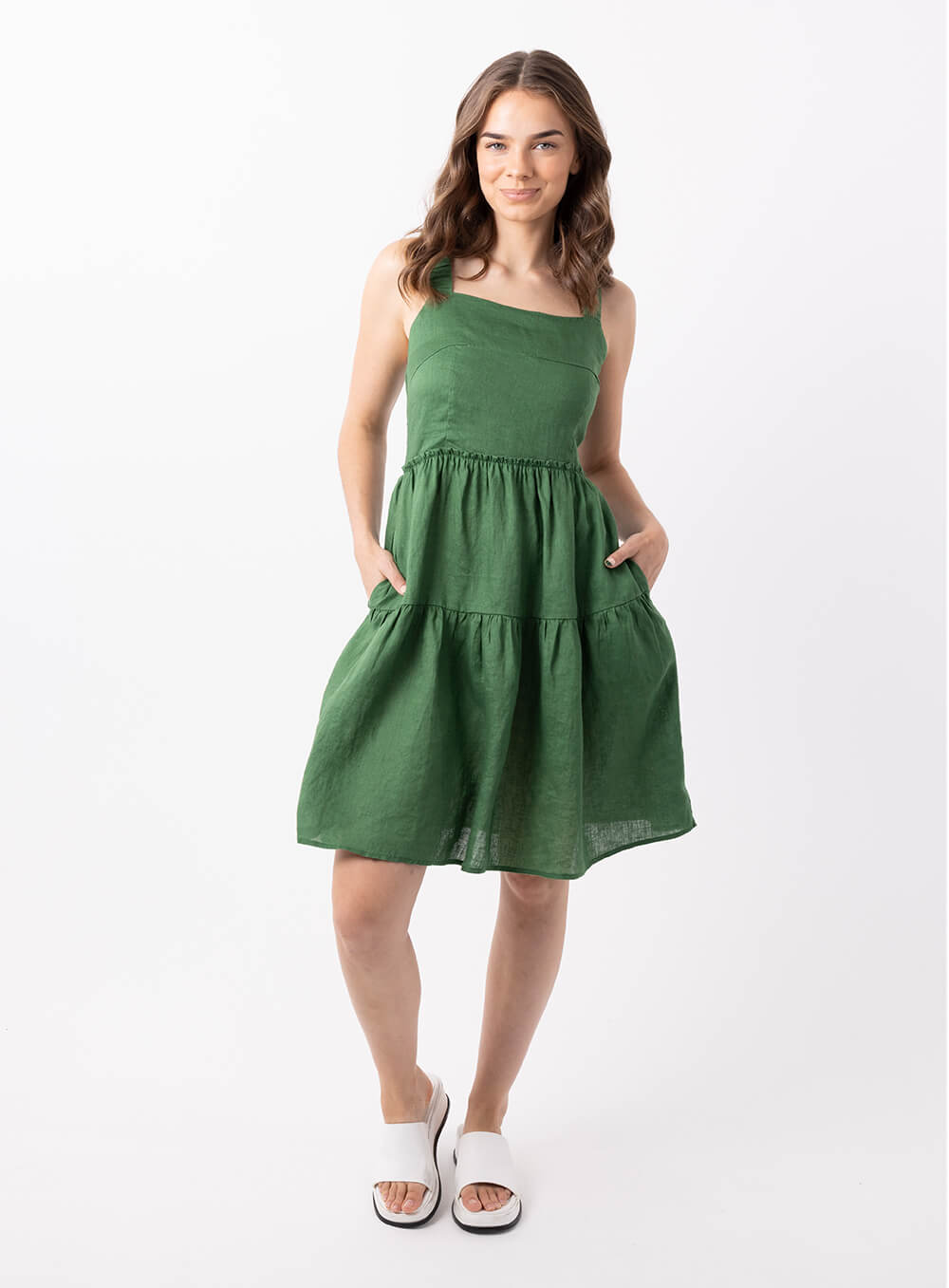 The Aquila linen dress in Green is 100% breathable linen midi in length with a tiered skirt, thin rouched straps and sqquare neckline