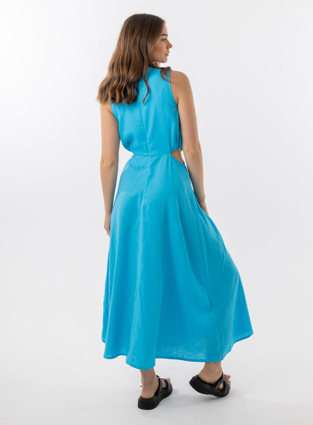 Bella Dress in Aqua features a gathered neckline, sleeveless, small cut outs at top and side of hips, with a a small ring above belly button and midi in length with a flowing skirt.