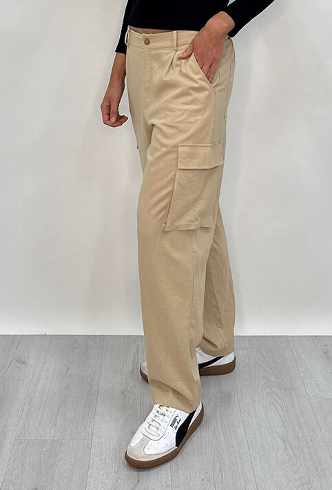 Athena Linen Cargo Pant in beige is 100% Linen, elastic waistband at back, belt loops, slightly tapered towards the hem, 2 Pockets at back, 2 Pockets on side leg