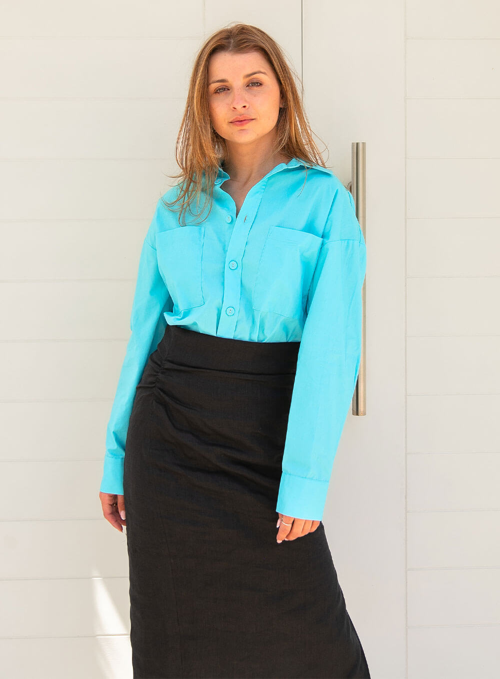 The Sienna Poplin Shirt in skye blue features button through front, scooped shirt hem style, self fabric covered buttons, luxe soft and breathable cotton poplin base