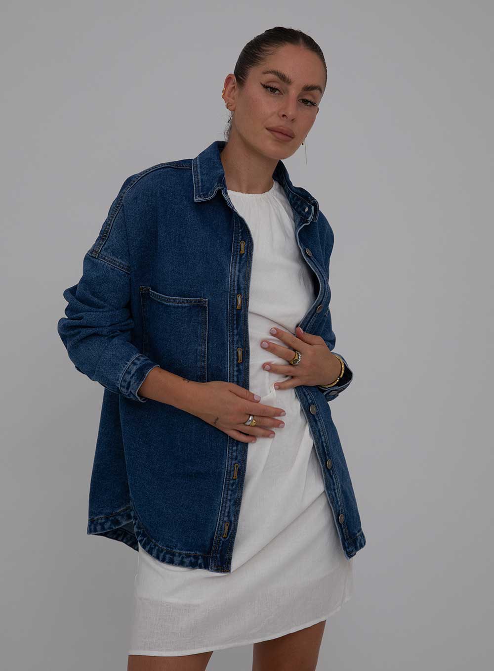 The Wake Up Denim Jacket in dark blue features full button through front, collar at the neck line, 2 large chest pockets, 2 side pockets, functional button down cuff adn scoop hem.