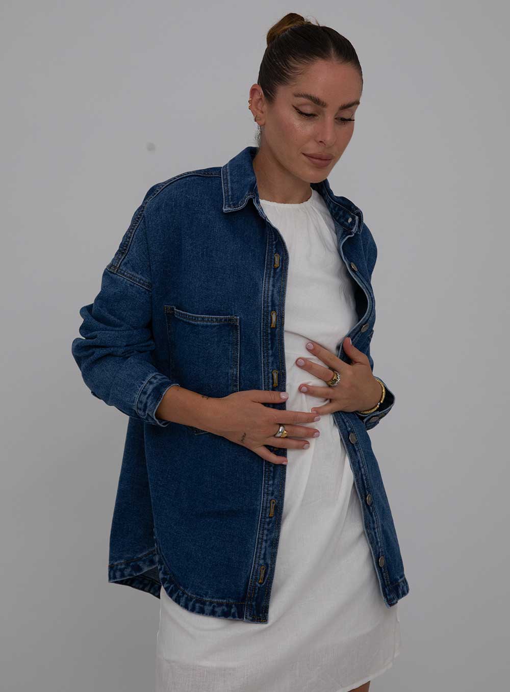The Wake Up Denim Jacket in dark blue features full button through front, collar at the neck line, 2 large chest pockets, 2 side pockets, functional button down cuff adn scoop hem.